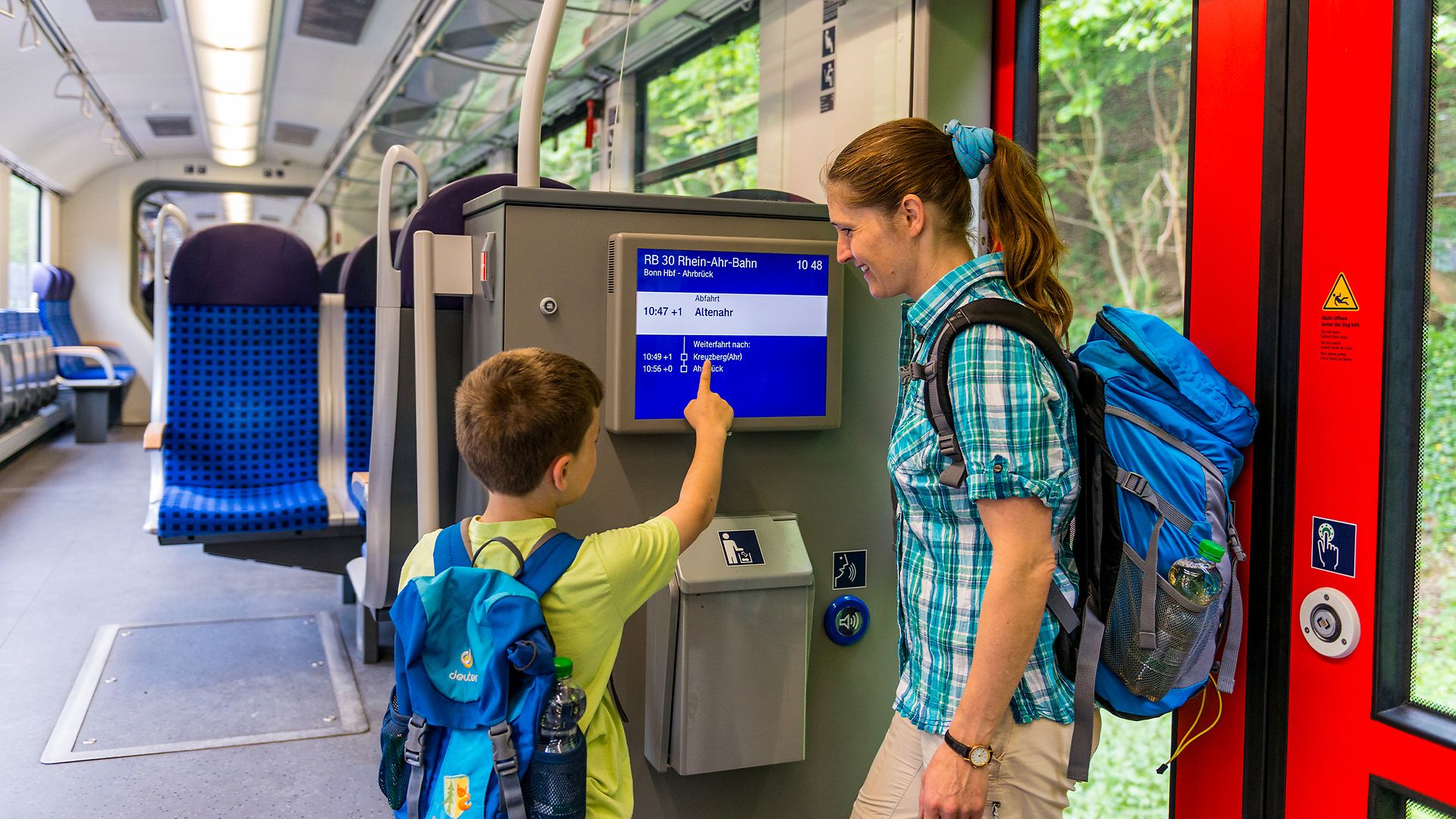 Mutter und Sohn im Zug am Bildschirm